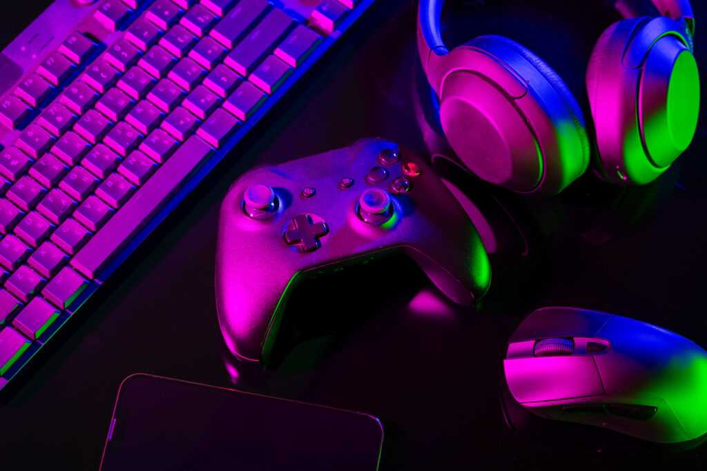 computer keyboard, mouse and joystick on black background